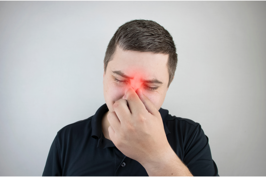 A man with sinusitis experiencing facial pain.
