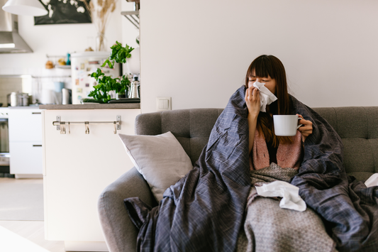 A woman sick with a summer cold blowing her nose.