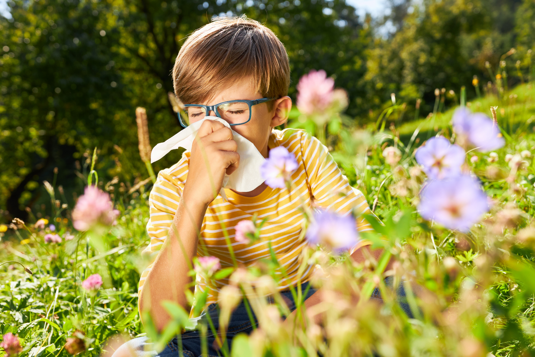 A young boy with a stuffy nose blowing his nose.