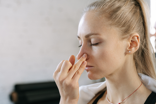 A young woman breathing through one nostril.