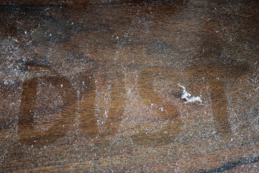 The word “dust” written on a dusty tabletop.