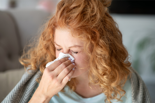 Woman with nasal congestion blowing her nose.